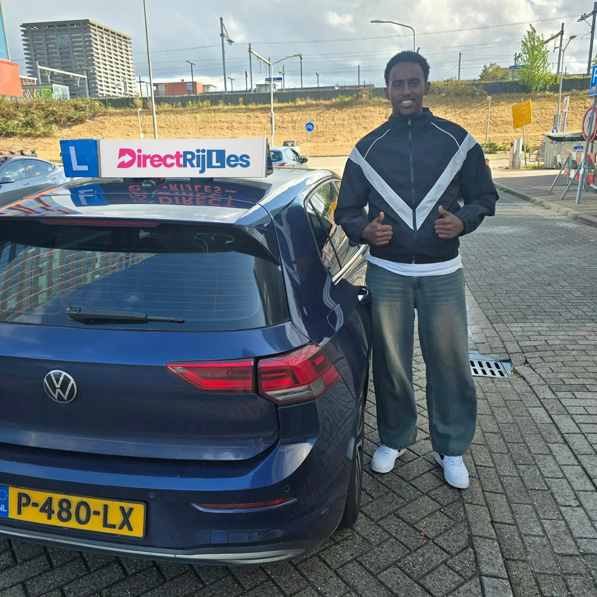 Geslaagde leerling naast de lesauto van Direct Rijles