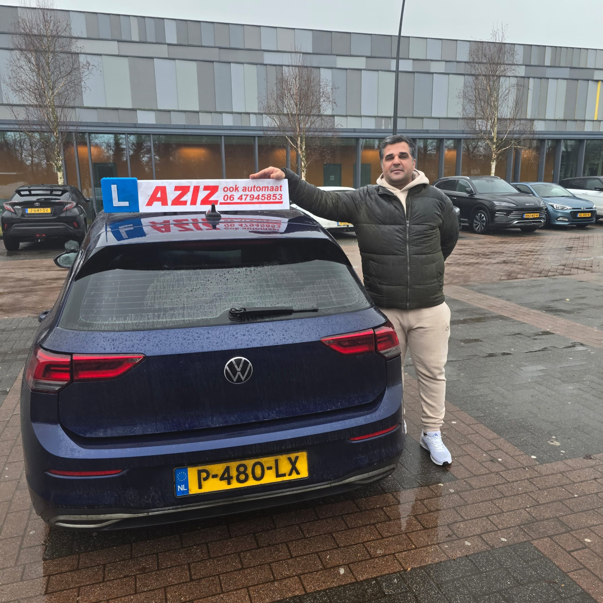 Geslaagde leerling naast de lesauto